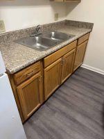 sink with new countertop and honey oak base sitting on new grey vinyl flooring